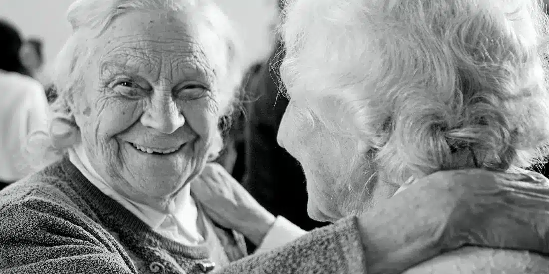 grayscale photo of woman in sweater smiling