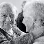 grayscale photo of woman in sweater smiling