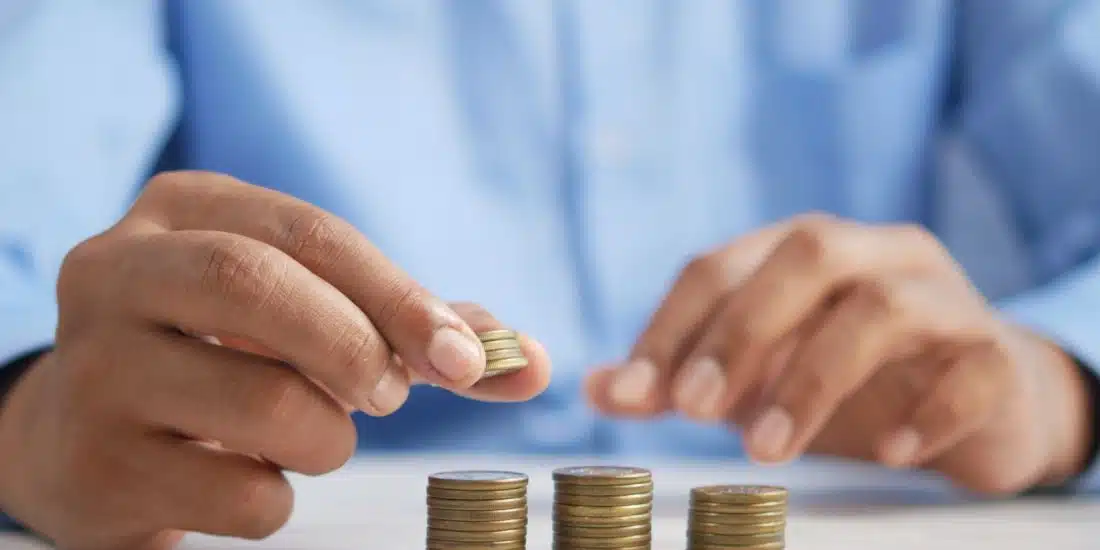 a person stacking coins on top of a table